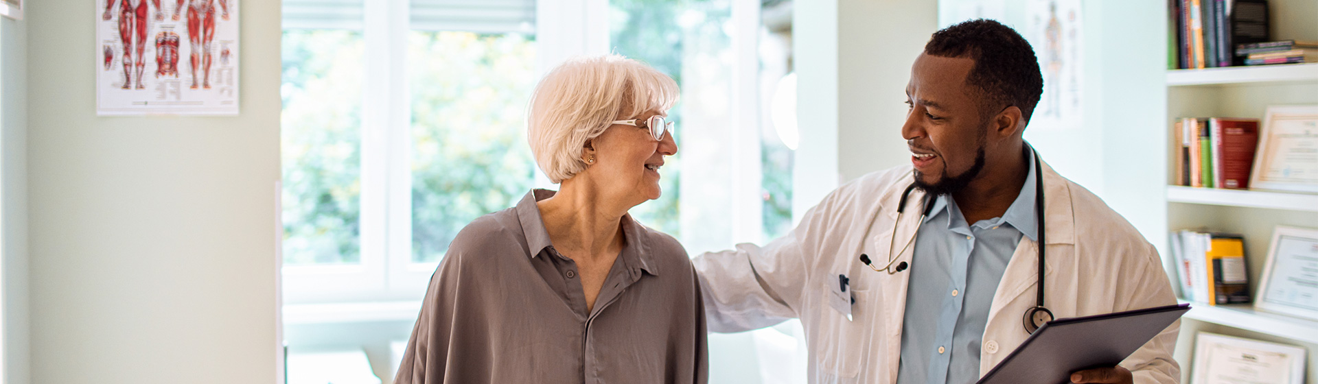 Doctor with clipboard smiles at patient