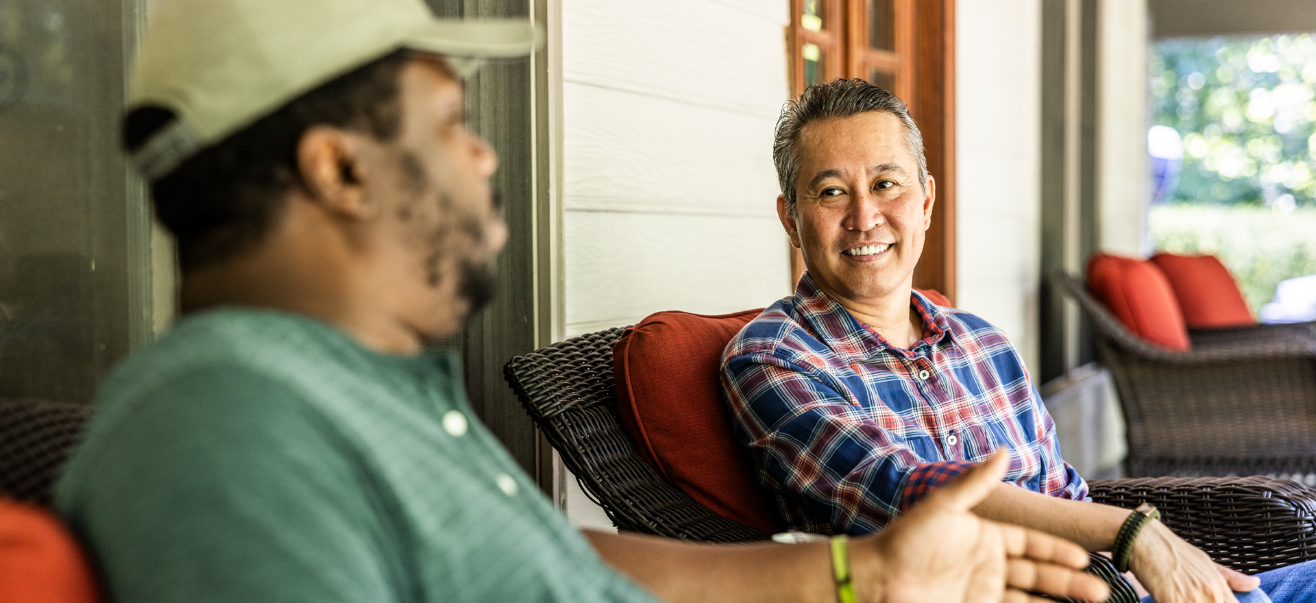 Two friends chat on a porch