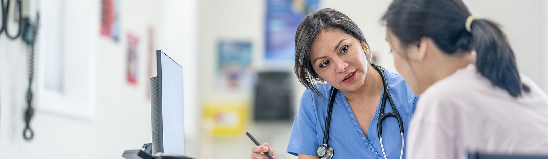 Doctor reviews notes with patient in medical office