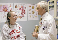 Donald E. Craven, MD, chair of the Department of Infectious Diseases, speaks with a patient during a clinical consultation
