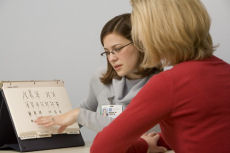 woman in red with practitioner reviewing breast health